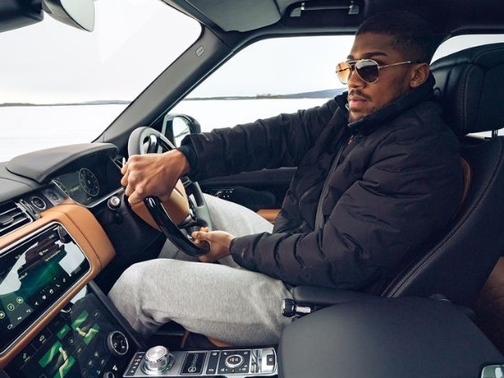 Anthony Joshua riding one of his expensive cars